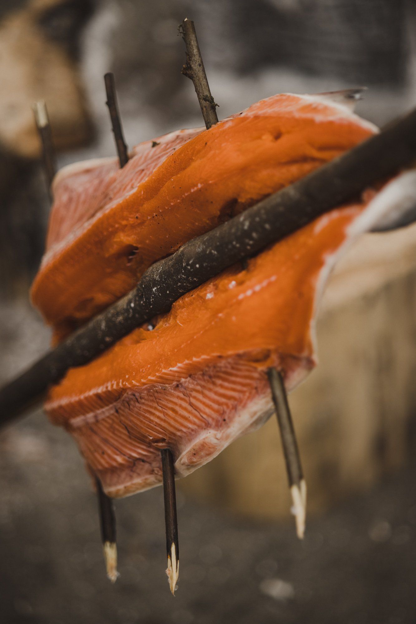 Orange fish with delicate fins held against dark wood, water droplets glistening in soft light