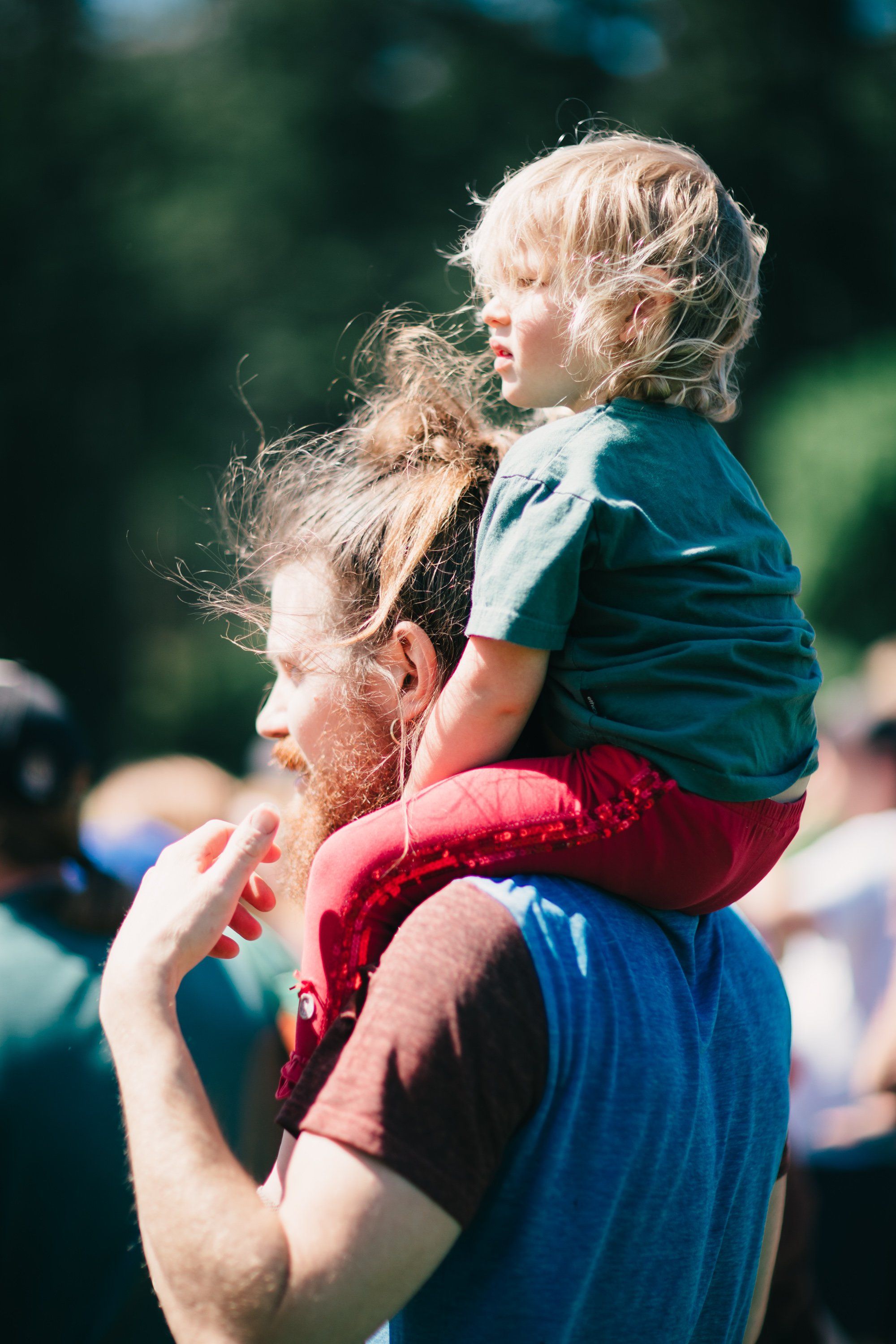 Father holds young daughter on shoulders in golden sunlight at Ruckle Farm, her blonde hair catching the light