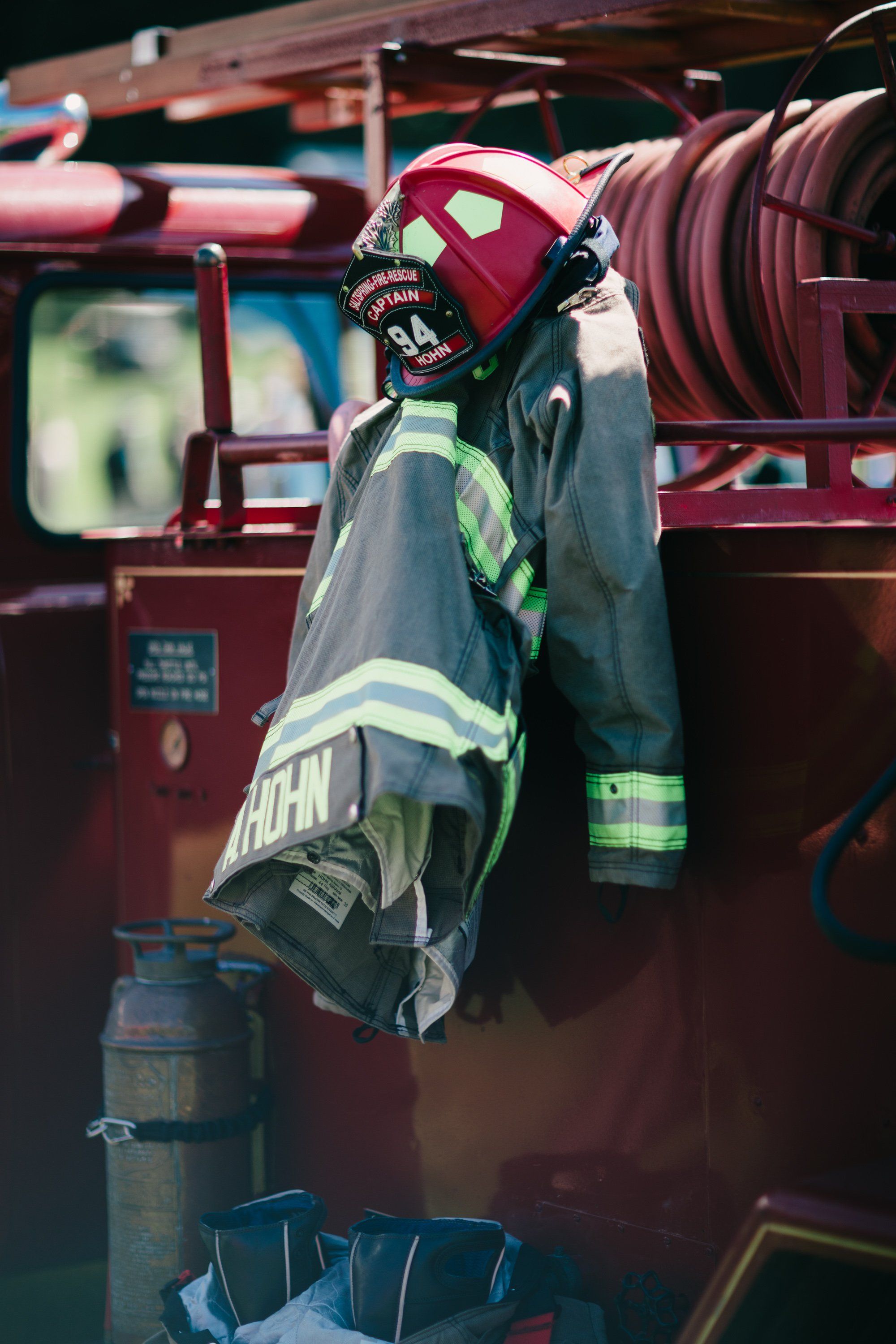 Firefighter's gear and helmet hang on vintage red fire truck equipment at Ruckle Farm
