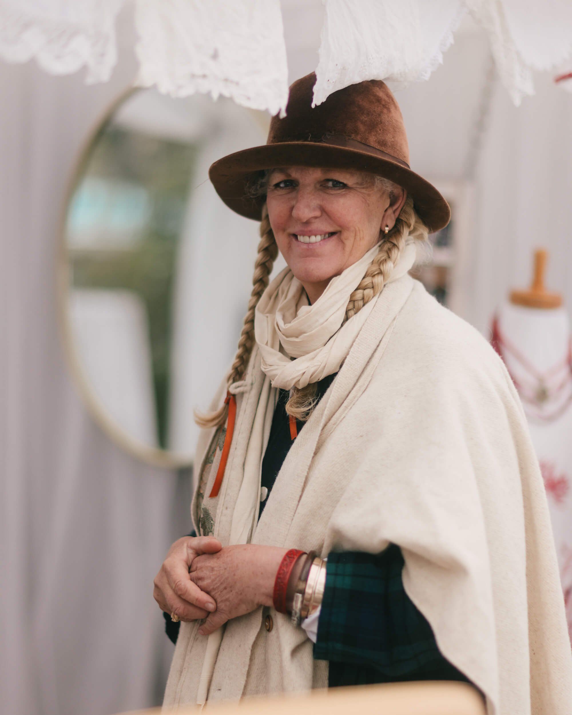 Smiling woman in brown hat and cream shawl at Salt Spring Island Saturday Market, braided hair and warm expression