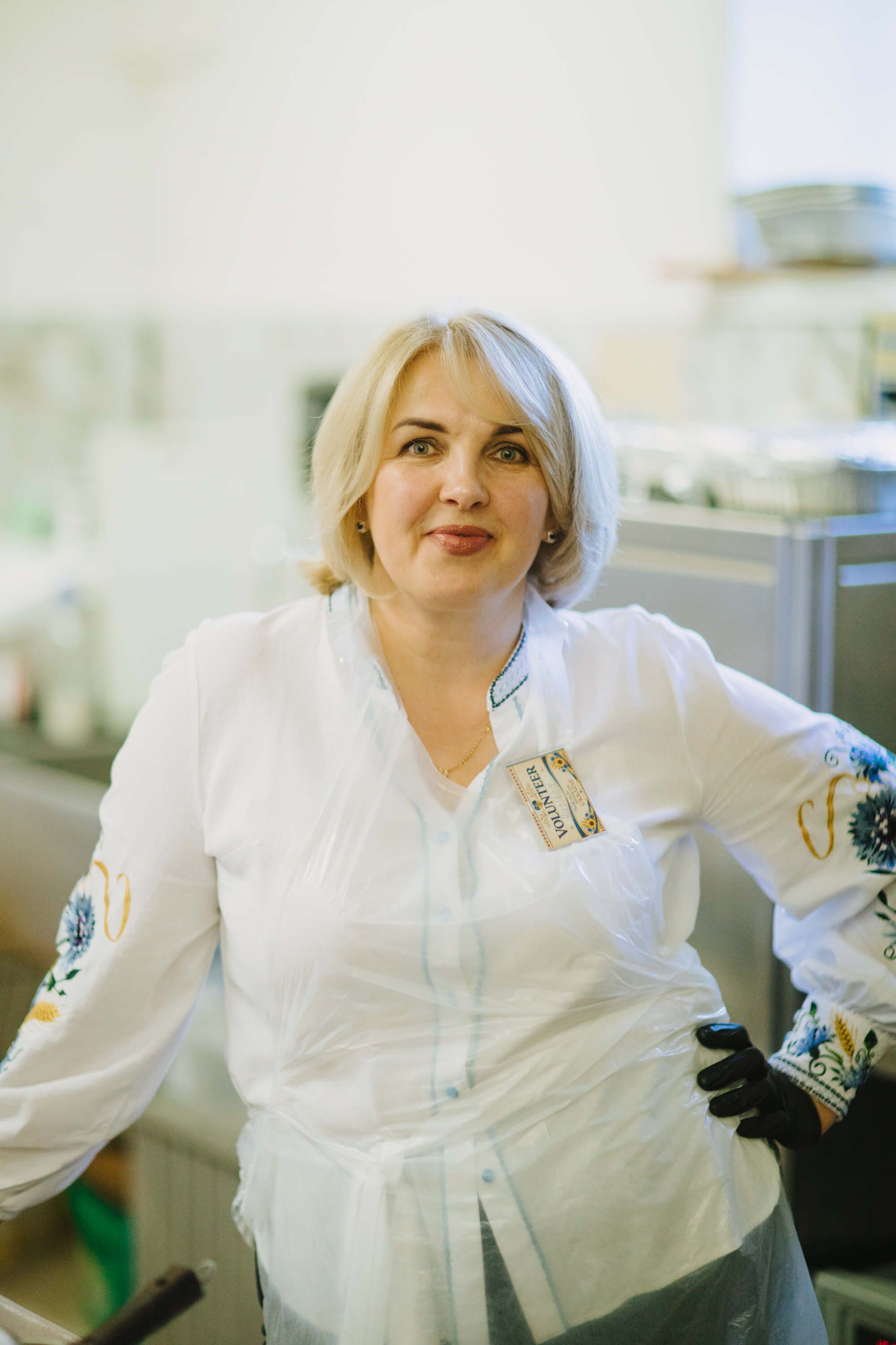 Woman in white embroidered blouse smiles in a bright kitchen setting during the Salt Spring Island Ukrainian Fundraiser Dinner
