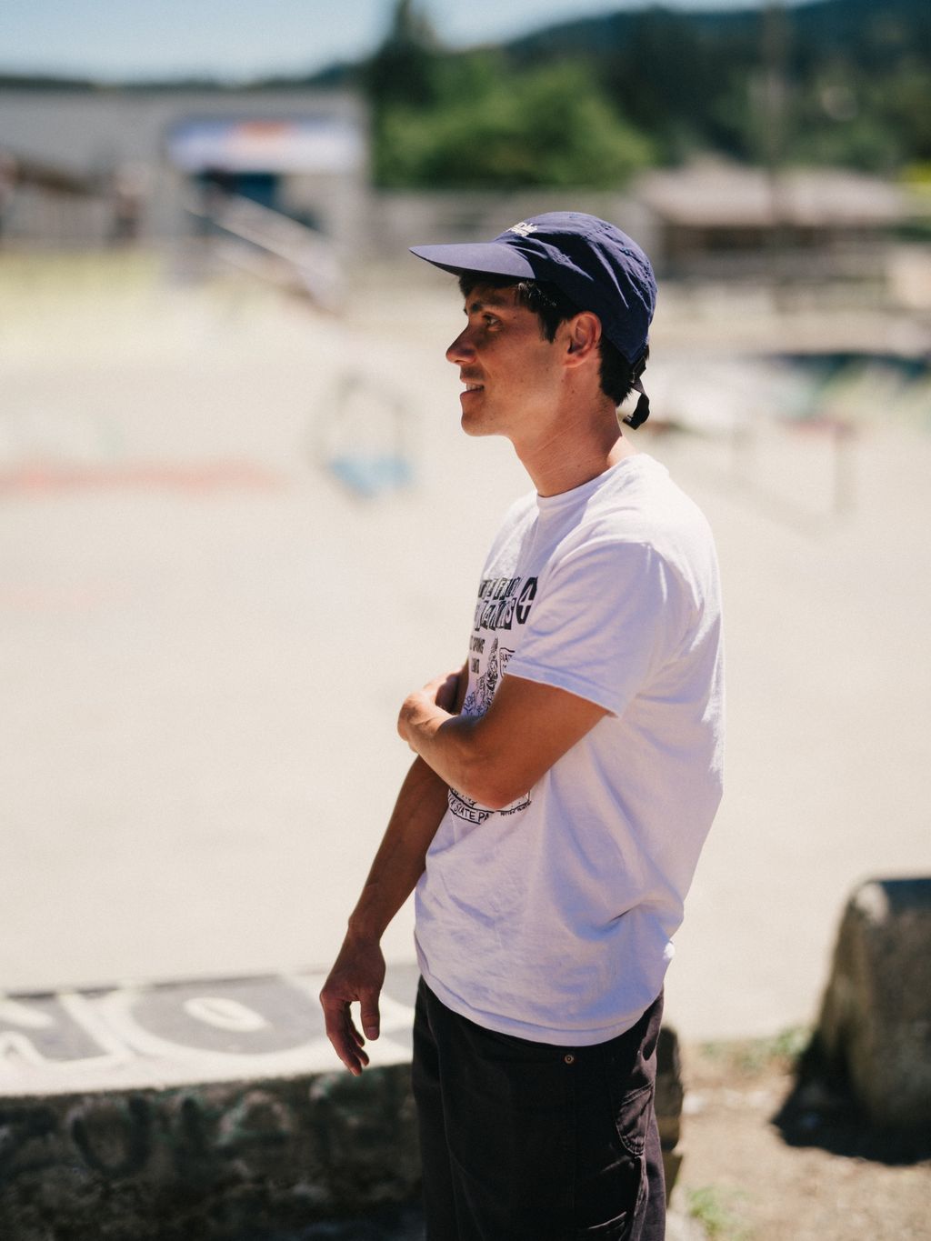 Young man smiles in profile at the Salt Spring Skatepark, wearing casual clothing and navy cap